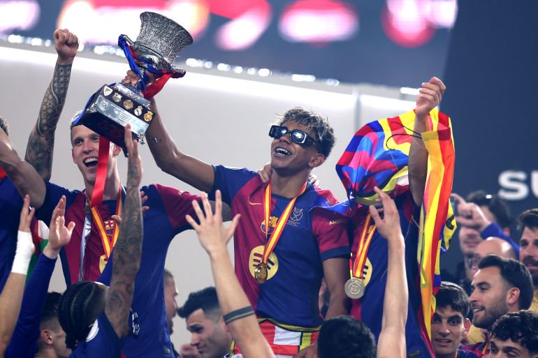 JEDDAH, SAUDI ARABIA - JANUARY 12: Lamine Yamal of FC Barcelona celebrates with the Supercopa de Espana trophy during the trophy presentation after the Spanish Super Cup Final between Real Madrid and FC Barcelona at King Abdullah Sports City on January 12, 2025 in Jeddah, Saudi Arabia. (Photo by Yasser Bakhsh/Getty Images)
