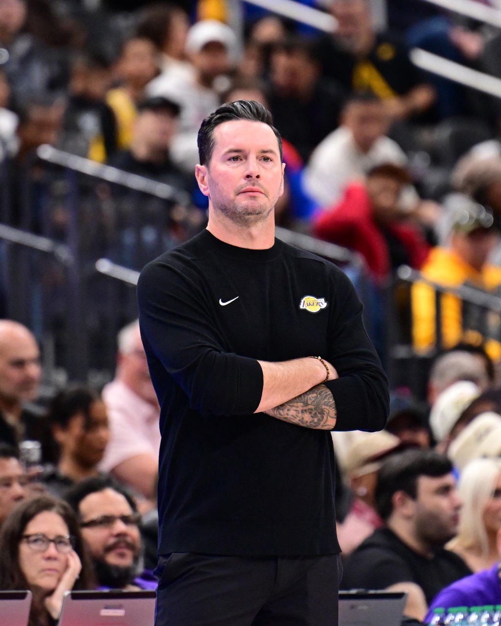Los Angeles Lakers head coach JJ Redick stands on the sideline with his arms crossed during a game against the Golden State Warriors.