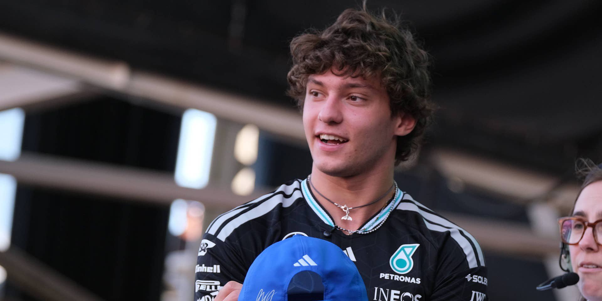 Junger Mann im Mercedes-Shirt hält eine blaue Kappe bei einer Formel-1-Veranstaltung in Austin.