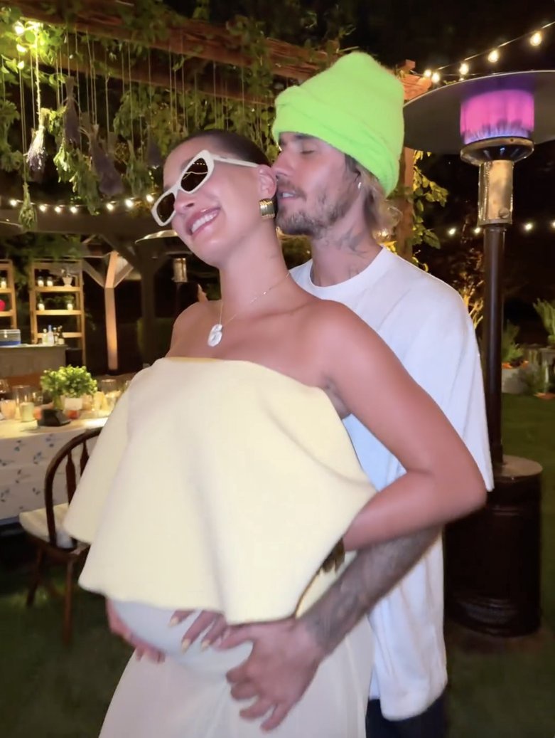 Justin Bieber hugs his pregnant wife Hailey Bieber from behind as she shows off her growing bump
