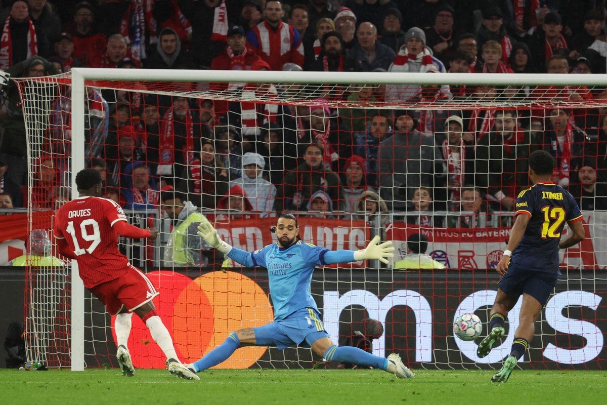 Bayerns Alphonso Davies (l.) trifft zum 1:1 gegen Arsenal-Keeper David Raya