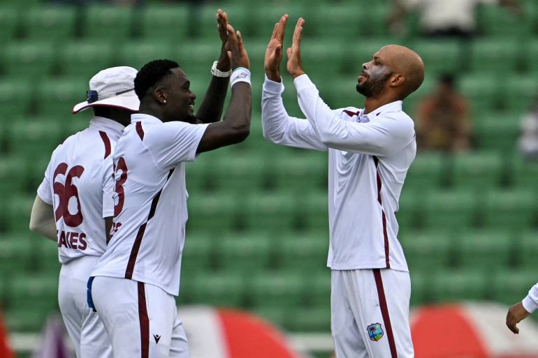 West Indies' captain Roston Chase (R) celebrates with teammates after taking the wicket of Bangladesh's Towhid Hridoy during the third day of the first test cricket match between Bangladesh and West Indies at the Sher-e-Bangla National Stadium in Mirpur on October 30, 2026. (Photo by Salahuddin Ahmed / AFP)