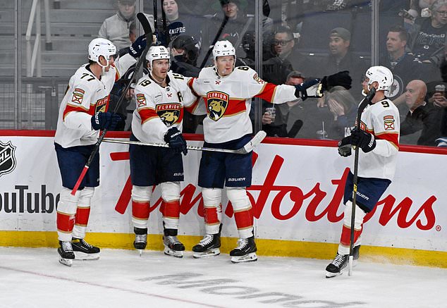 Florida Panthers' Brady Tkachuk (8) celebrates his goal on the Winnipeg Jets with Niko Mikkola (77), Matthew Tkachuk (19) and Sam Bennett (9) during third period NHL action in Winnipeg on Tuesday, Oct. 27, 2026. (Fred Greenslade/The Canadian Press via AP)
