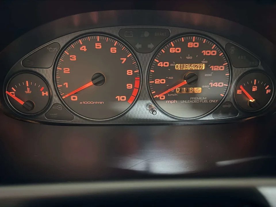 Orange-lit gauge cluster of a 2000 Acura Integra Type R showing the tachometer and 19,427 odometer reading