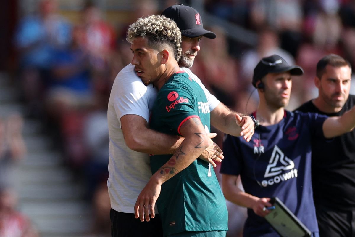 Liverpool's German manager Jurgen Klopp embraces Liverpool's Brazilian striker Roberto Firmino as he leaves, substituted after making his final Liverpool appearance during the English Premier League football match between Southampton and Liverpool at St Mary's Stadium in Southampton, southern England on May 28, 2023.