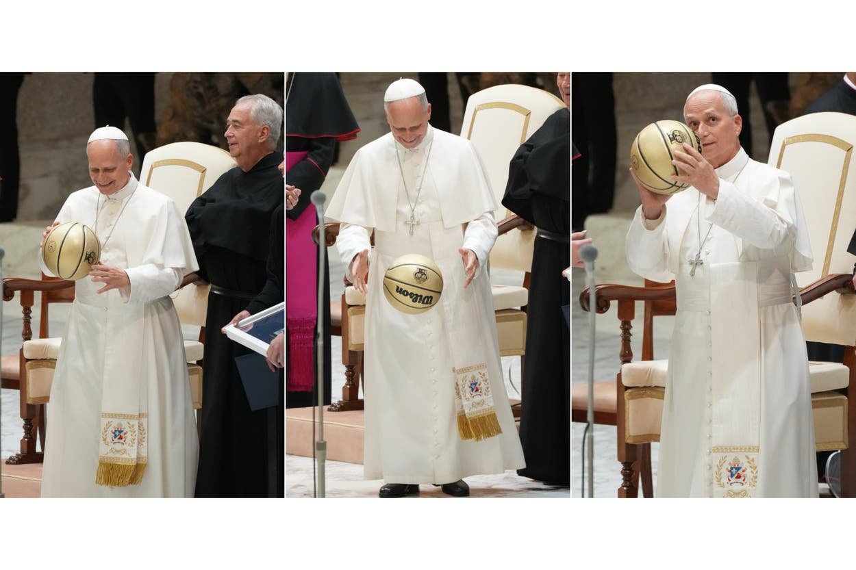 Pope Leo XIV examines a basketball he received in the Paul VI Hall at the Vatican, Saturday, Oct. 31, 2026