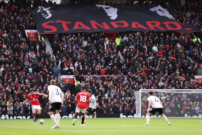 Manchester United fans unfurl a banner featuring the faces of Eric Cantona, Bryan Robson and Roy Keane over the word "Standards". Photograph: Dan Mullan/Getty Images  