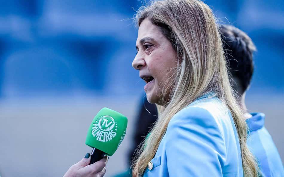 Leila Pereira em entrevista, segurando microfone verde da TV Palmeiras.