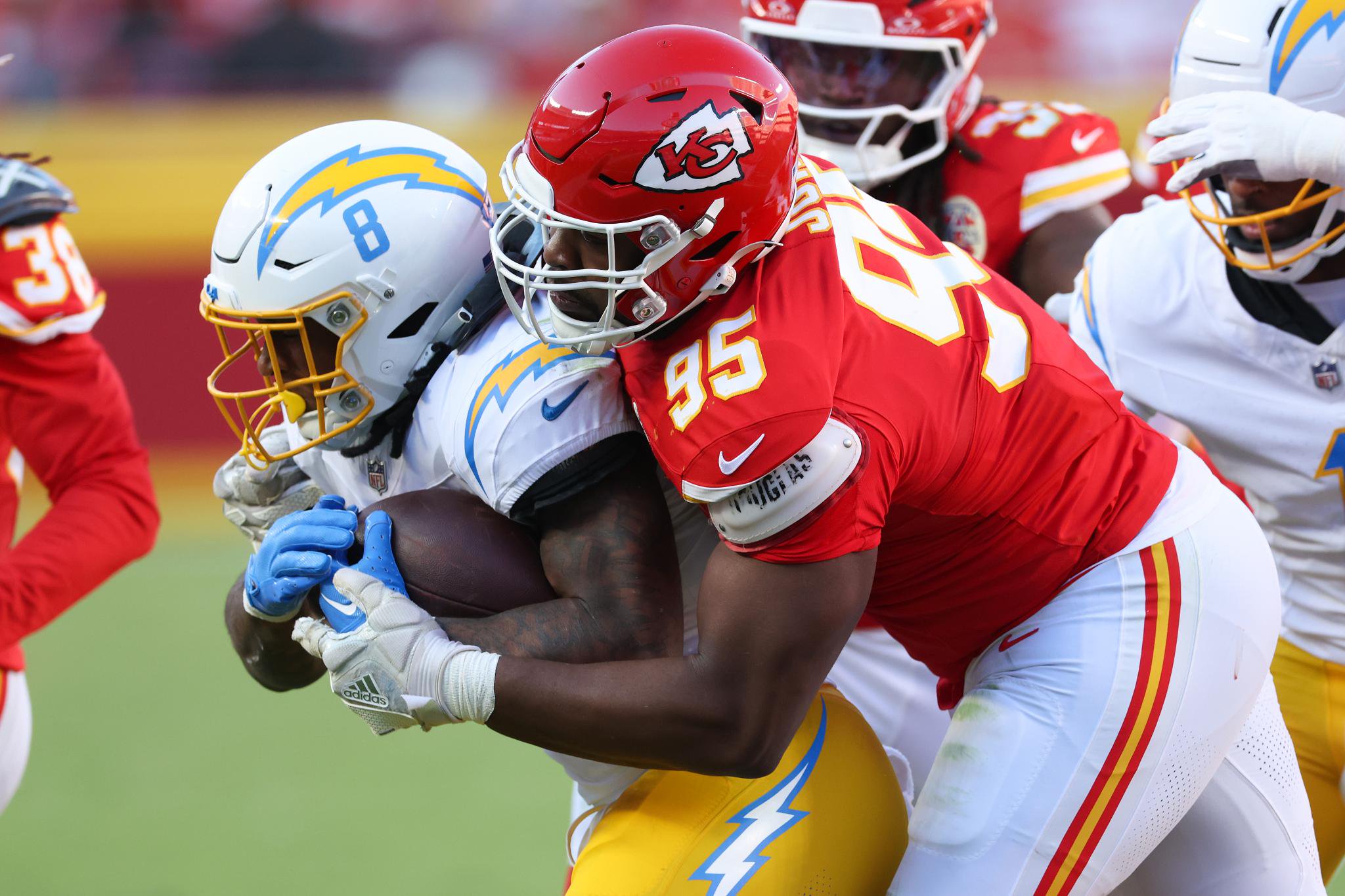 Kansas City Chiefs player tackles a Los Angeles Chargers player during a game.