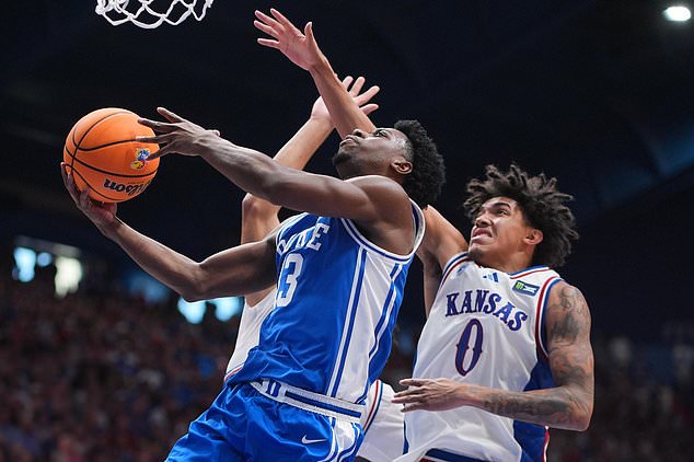 Duke's John Blackwell (13) gets past Kansas' Taylen Kinney (0) to put up a shot during the second half of an exhibition NCAA college basketball game Sunday, Oct. 25, 2026, in Lawrence, Kan. (AP Photo/Charlie Riedel)