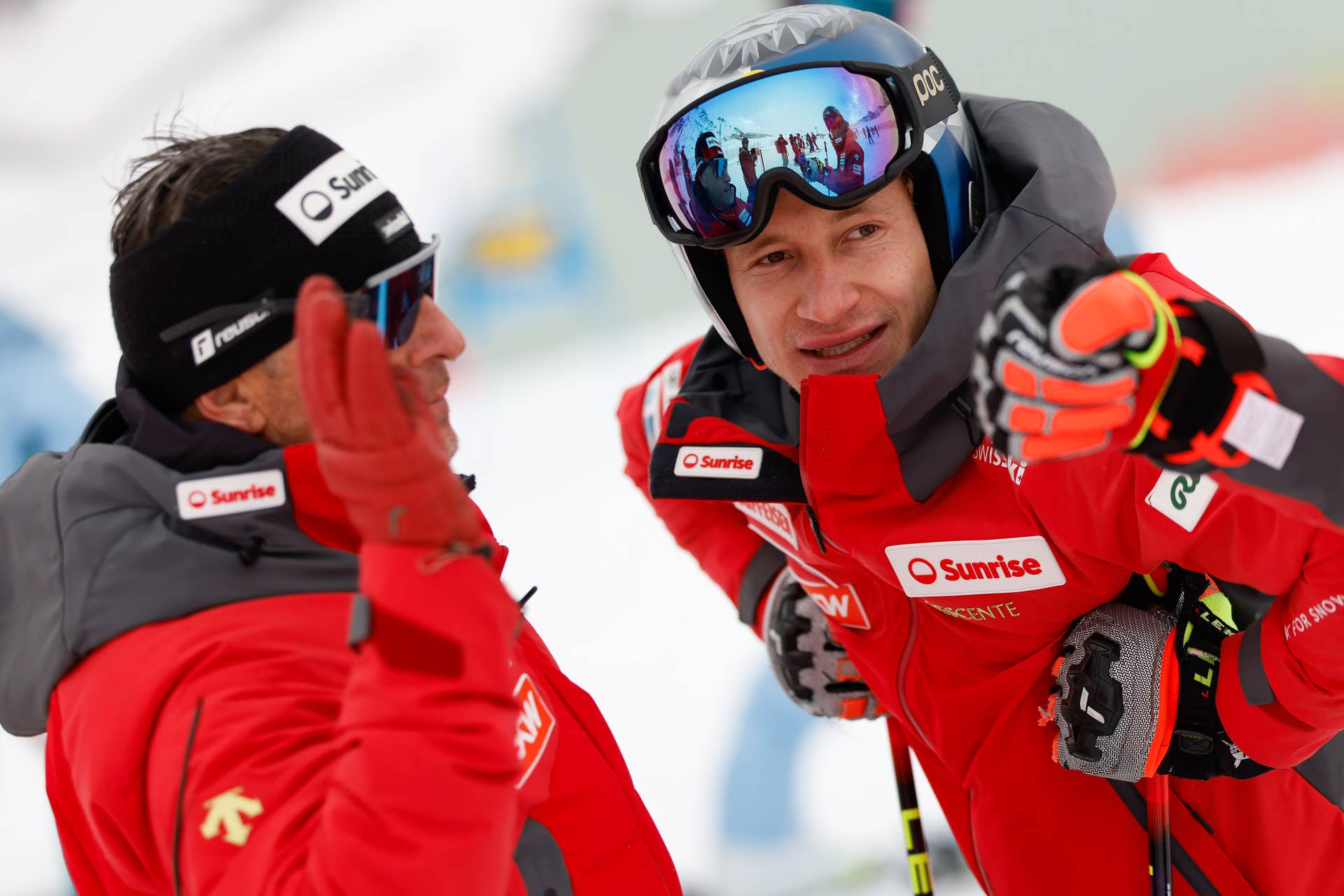 Zwei Skifahrer in roter Teamkleidung unterhalten sich auf einer Skipiste in Sölden.
