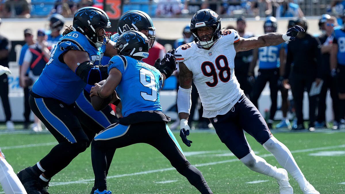 Montez Sweat pressures Bryce Young during an NFL game at Bank of America Stadium.