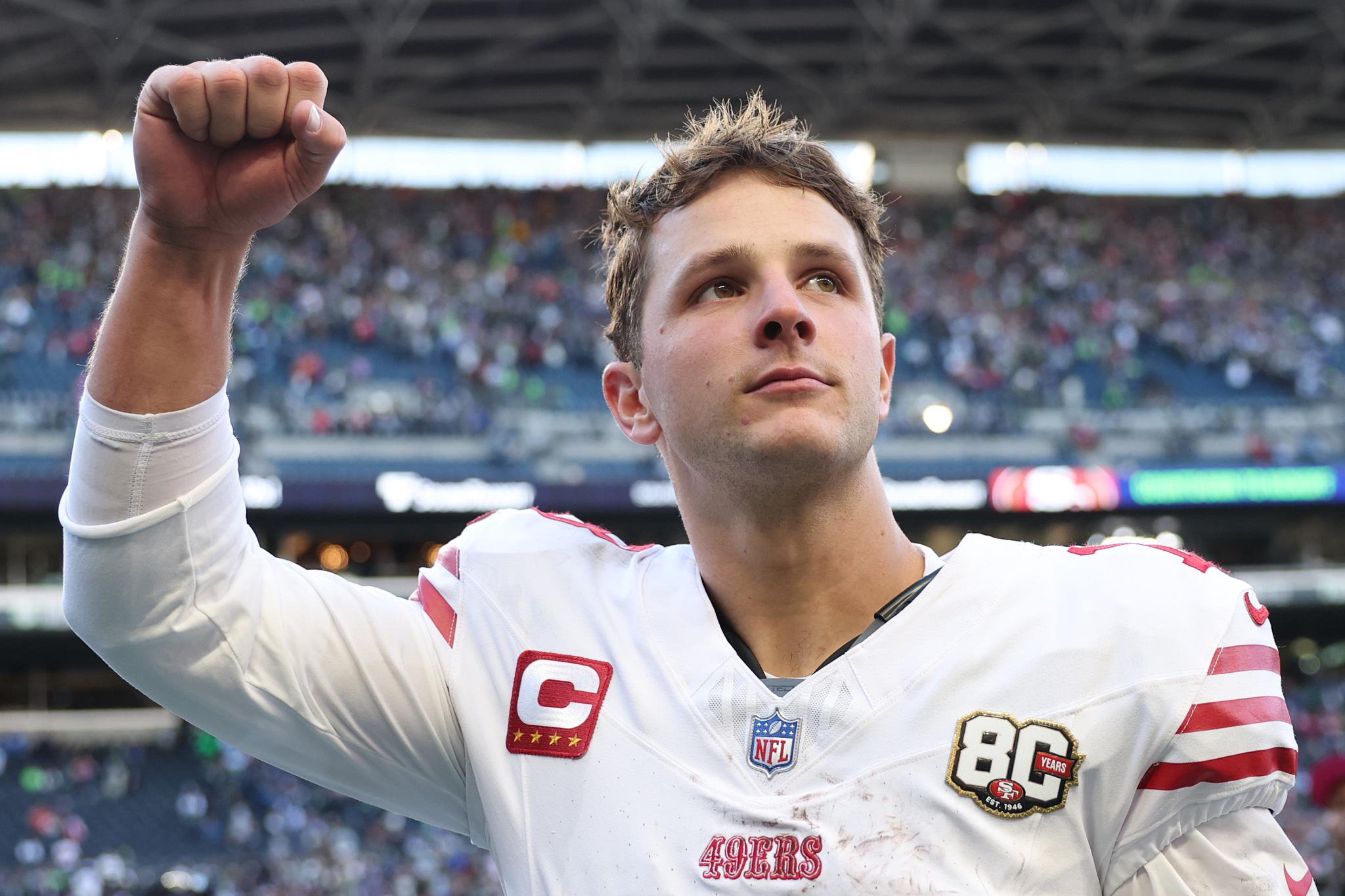 San Francisco 49ers quarterback Brock Purdy celebrates a victory with a raised fist.