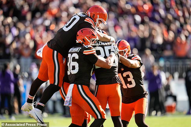 Cleveland Browns long snapper Rex Sunahara, left, and others pile on place kicker Andre Szmyt, second from right, after his game-winning field goal during the second half of an NFL football game against the Baltimore Ravens in Cleveland, Sunday, Oct. 18, 2026. (AP Photo/Sue Ogrocki)