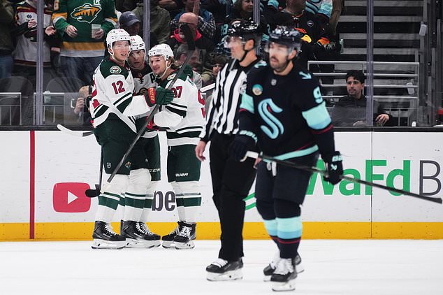 Minnesota Wild center Joel Eriksson Ek (14) celebrates scoring against the Seattle Kraken with left wing Matt Boldy (12) and left wing Kirill Kaprizov (97) during the second period of an NHL hockey game Saturday, Oct. 24, 2026, in Seattle. (AP Photo/Lindsey Wasson)