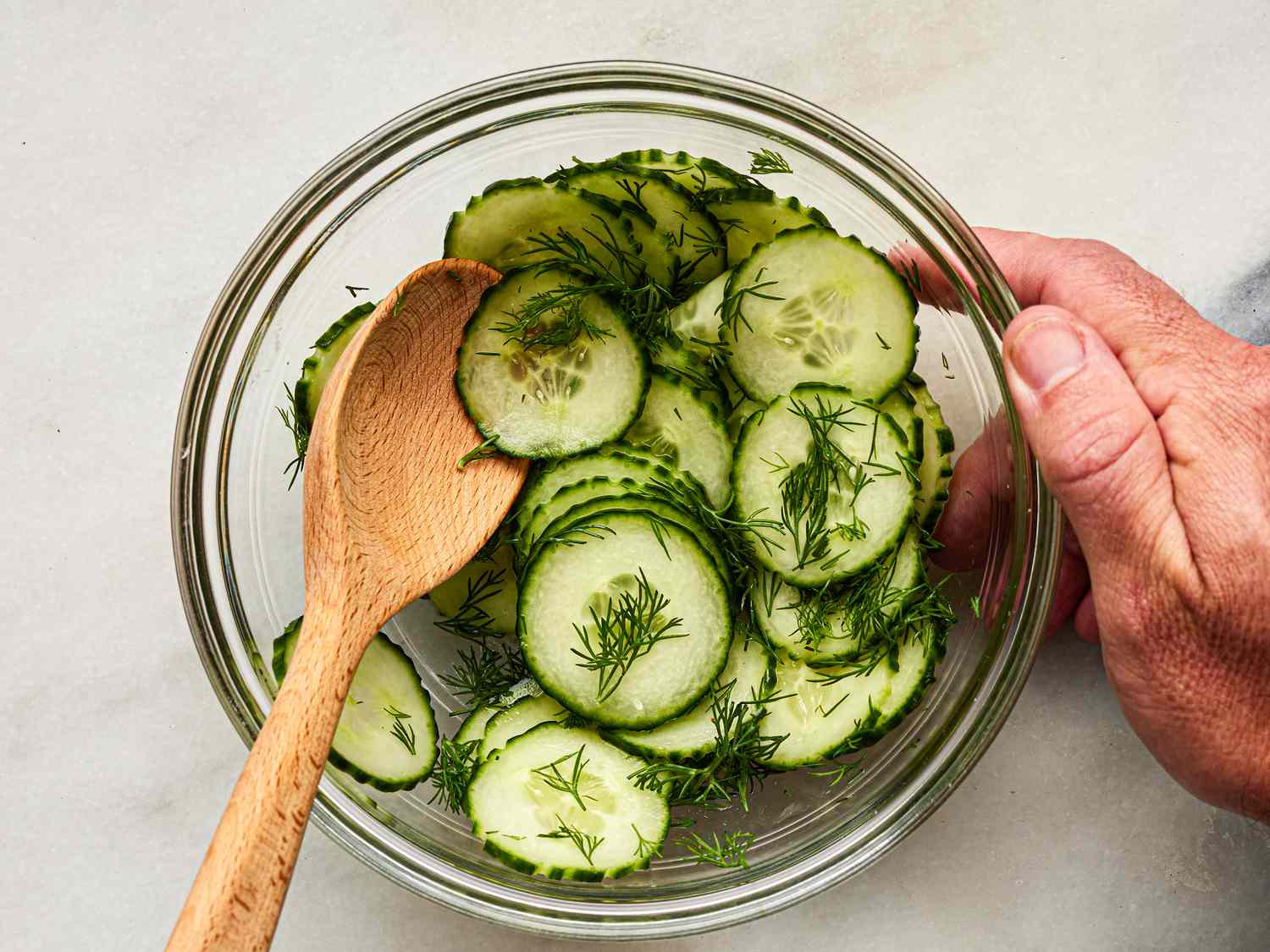 Overhead view of cucumbers tossed with dill