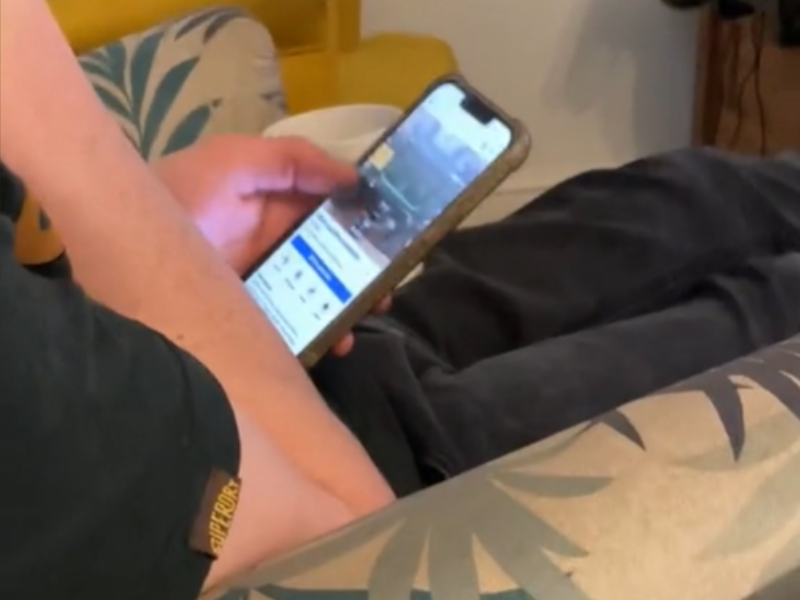 A man scrolling through Facebook Marketplace on his smartphone