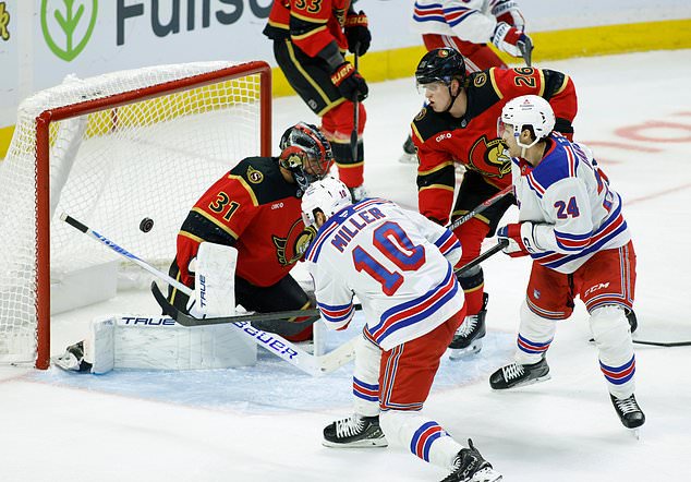 New York Rangers' J.T. Miller (10) scores on Ottawa Senators goaltender Jonas Johansson (31) as Senators' Carter Yakemchuk (26) and Rangers' Tye Kartye (24) look on during second period NHL hockey action in Ottawa on Saturday, Oct. 24, 2026. (Patrick Doyle/The Canadian Press via AP)