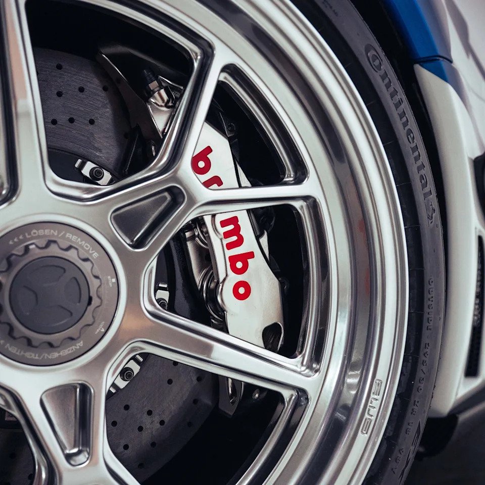 Close-up of a car wheel showing a Brembo brake caliper and a Continental tire.