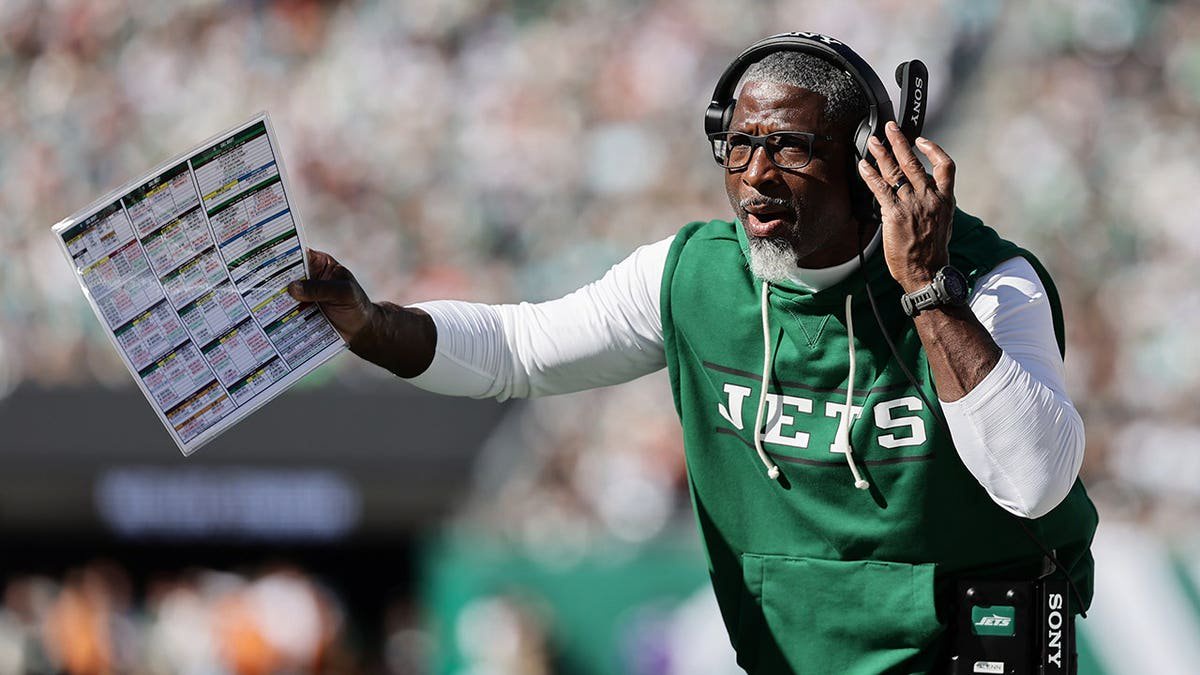 Aaron Glenn stands on the sideline during an NFL game between the Jets and Dolphins.