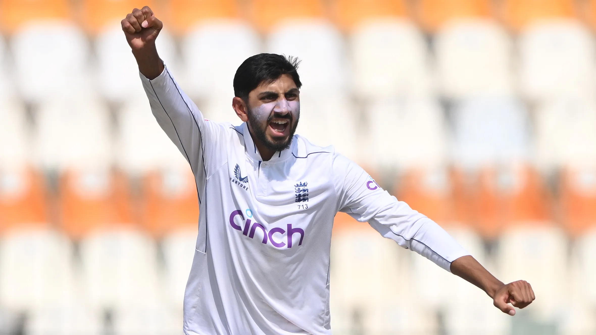 England bowler Shoaib Bashir celebrates with white sunscreen on his face.