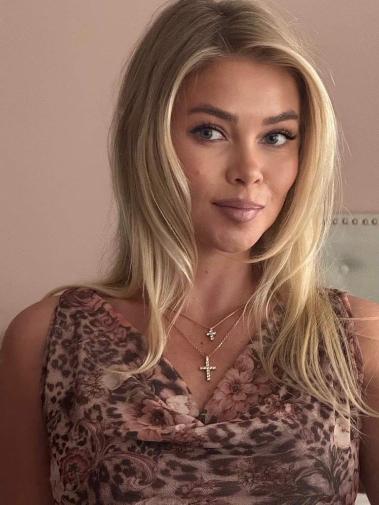 A portrait of Hailey wearing a floral print top and two cross necklaces.