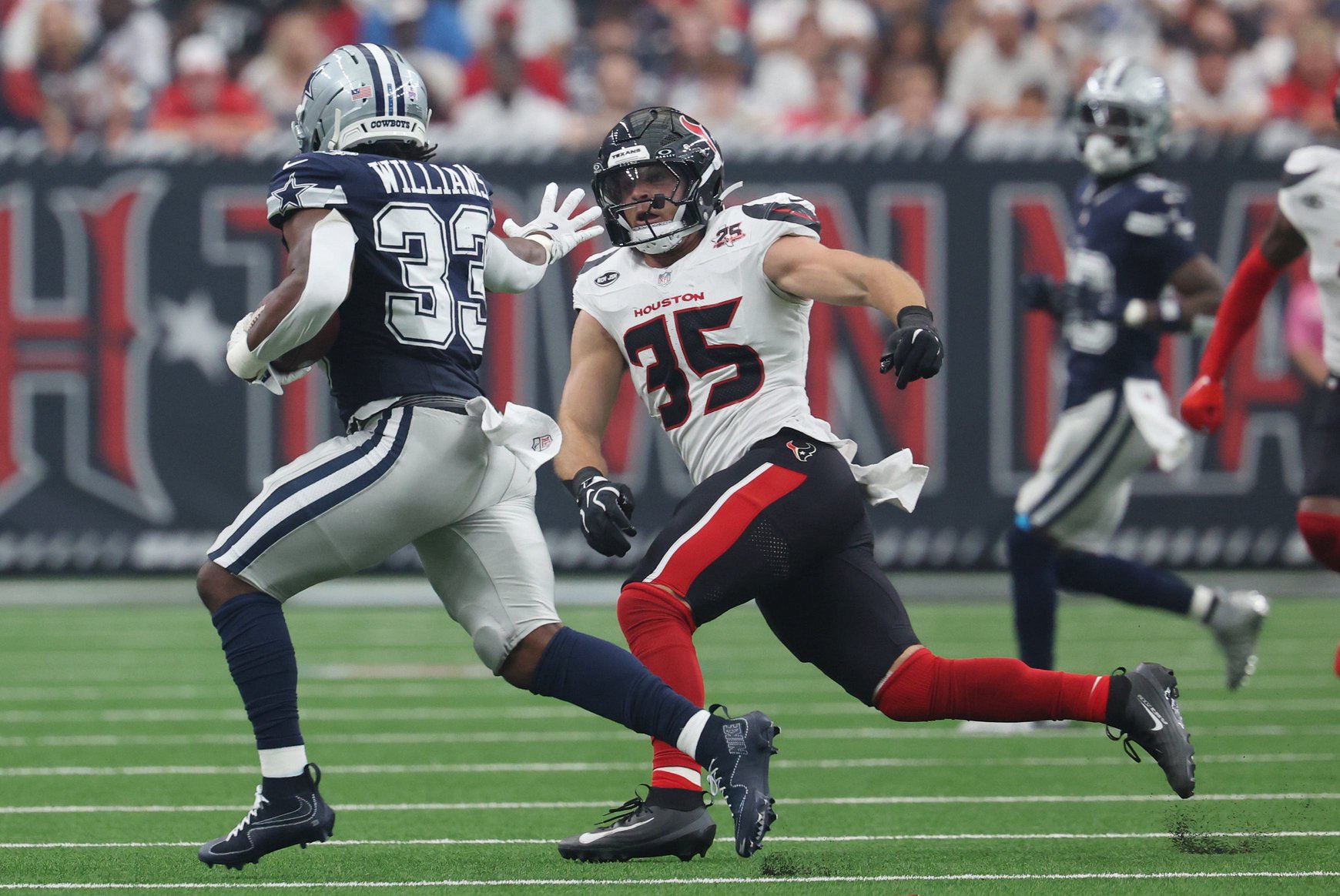 Oct 4, 2026; Houston, Texas, USA;  Dallas Cowboys running back Javonte Williams (33) carries the ball as Houston Texans linebacker Jake Hansen (35) defends during the first half at Reliant Stadium.  Mandatory Credit: Thomas Shea-Imagn Images