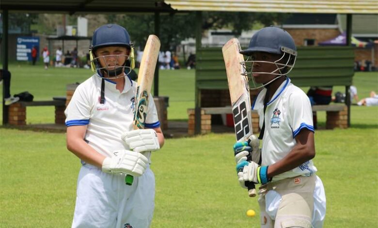 Two players in their cricket gear.