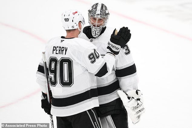 Los Angeles Kings goaltender Darcy Kuemper, right, celebrates with right wing Corey Perry (90) after an NHL hockey game against the Washington Capitals, Tuesday, Oct. 20, 2026, in Washington. (AP Photo/Nick Wass)
