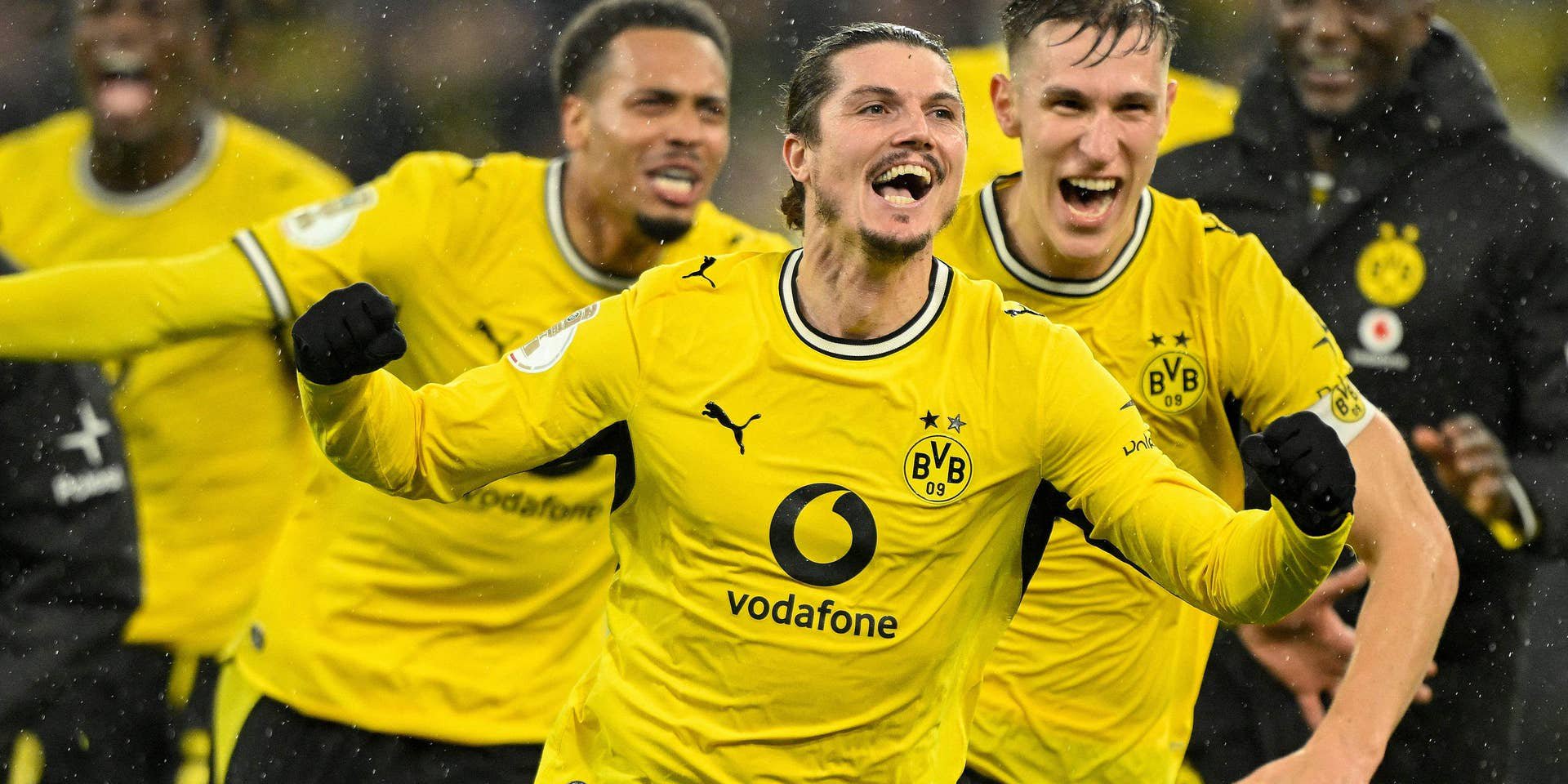 Mehrere Borussia-Dortmund-Spieler jubeln im gelben Trikot nach einem Tor im Fußballstadion.