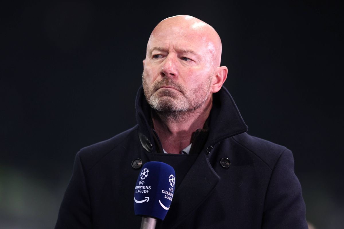 Alan Shearer looks on while holding a Champions League microphone