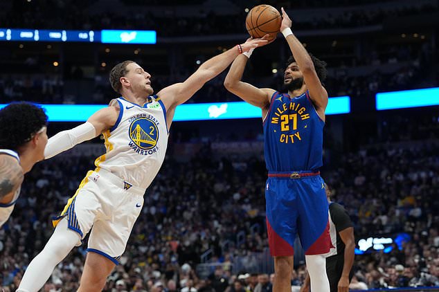 Denver Nuggets guard Jamal Murray, right, goes up to shoot as Golden State Warriors guard Brandin Podziemski (2) defends in the first half of an NBA basketball game Monday, Oct. 26, 2026, in Denver. (AP Photo/David Zalubowski)