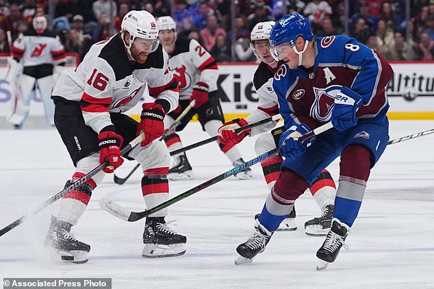 Colorado Avalanche defenseman Cale Makar, right, passes the puck as New Jersey Devils right wing Connor Brown defends in the second period of an NHL hockey game Wednesday, Oct. 28, 2026, in Denver. (AP Photo/David Zalubowski)