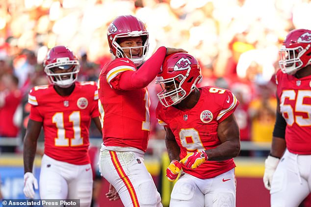 Kansas City Chiefs quarterback Patrick Mahomes, center left, and Kenneth Walker III (9) celebrate a touchdown scored on a rushing play by Walker III during the first half of an NFL football game against the Los Angeles Chargers in Kansas City, Mo., Sunday, Oct. 18, 2026. (AP Photo/Ed Zurga)