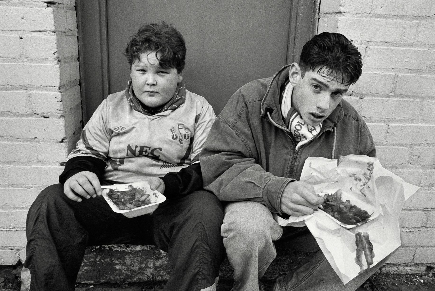 In 1991, photographer Richard Davis followed supporters from across the North West for a book about football, fashion and music. Richard spent much of the season taking pictures of fans from Liverpool, Everton and more for the book Football With Attitude. In collaboration with Lower Block, the Going to the Match zine has been published to coincide with an exhibition of the same name at Bury Art Museum, running from October 2024 to March 2025.
Pictured: Everton Fans at Goodison Park, 1991