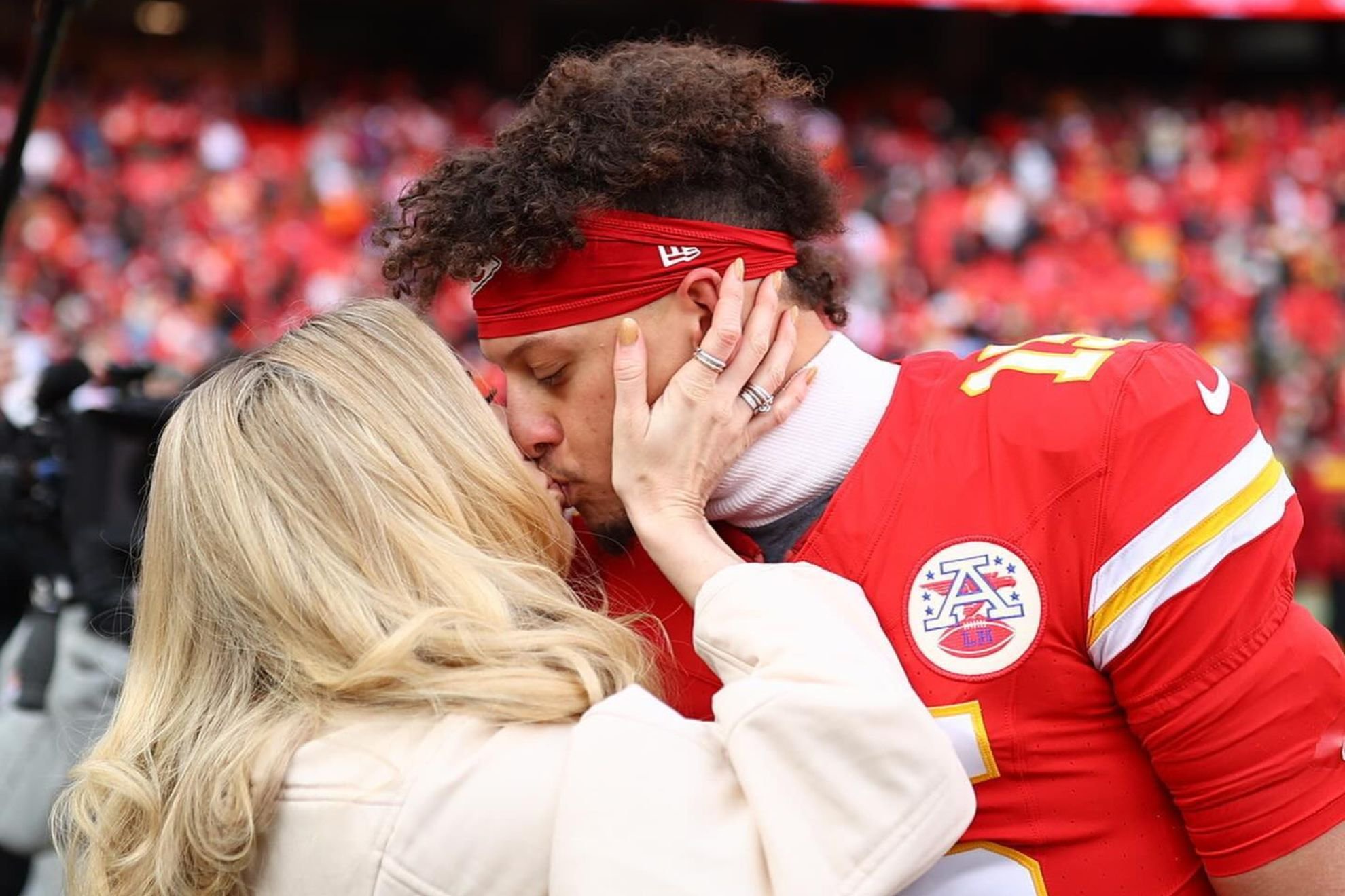 Patrick Mahomes and Brittany Mahomes share a kiss before the game begins