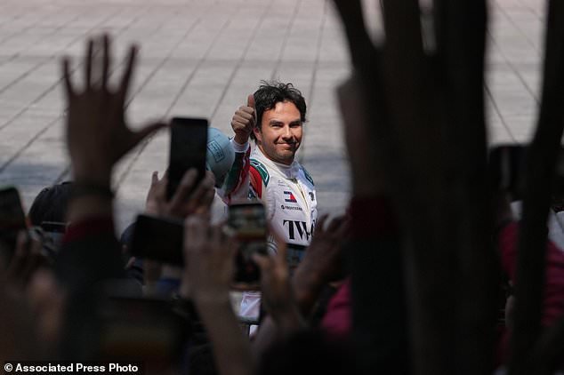 Mexican driver Sergio Perez of the Cadillac F1 Team waves to the crowd during his exhibition drive along Paseo de la Reforma in Mexico City, Wednesday, Oct. 28, 2026. (AP Photo/Eduarto Verdugo)