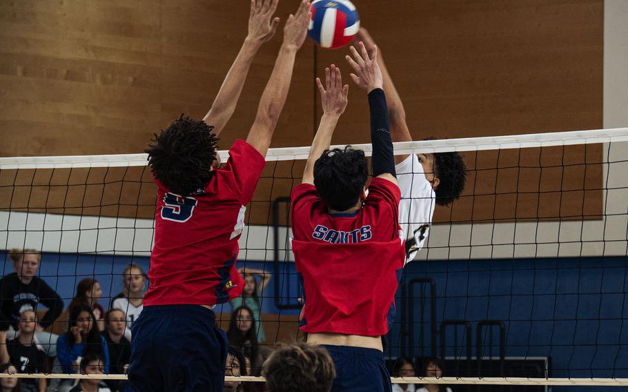 Three players battle at the net.