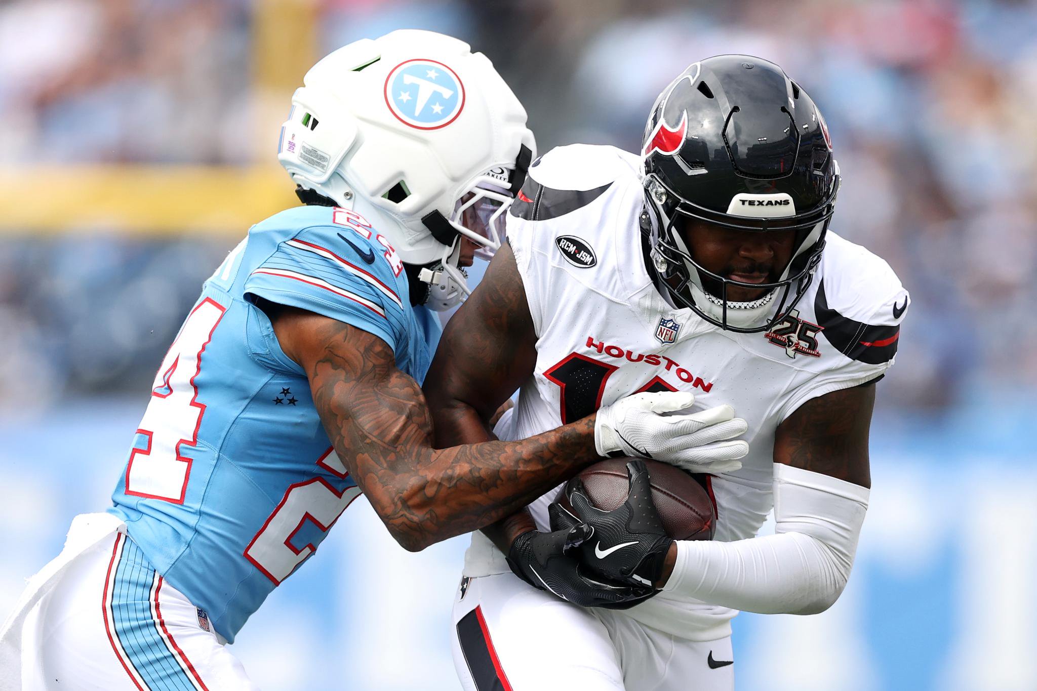 Alontae Taylor of the Tennessee Titans tackles Kayshon Boutte of the Houston Texans.