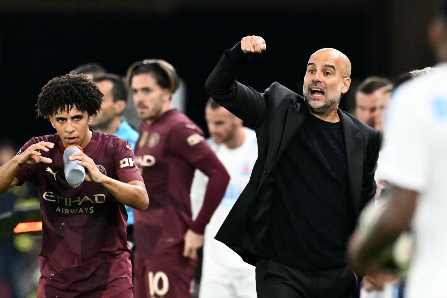 Manchester City's Spanish manager Pep Guardiola (R) reacts next to Manchester City's English defender #82 Rico Lewis during the UEFA Champions Leag...