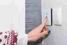 a person touching a smart light switch