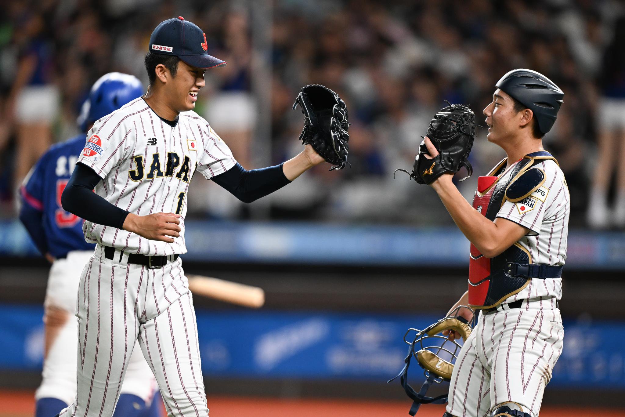 Shoki Oda #11 of Team Japan interacts with Ritora Yamada #2 of Team Japan on the field.