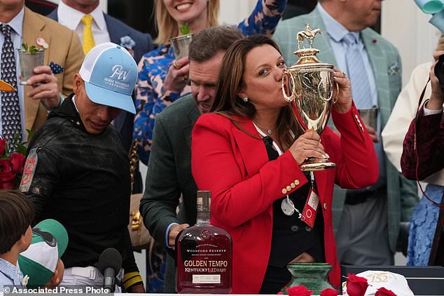 FILE - Trainer Cherie DeVaux kisses the trophy after a victory by Golden Tempo in the 152nd running of the Kentucky Derby horse race at Churchill Downs, May 2, 2026, in Louisville, Ky. (AP Photo/Abbie Parr, File)