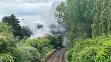 Network Rail Wessex Trees and bushes either side of train tracks with thick black smoke billowing across