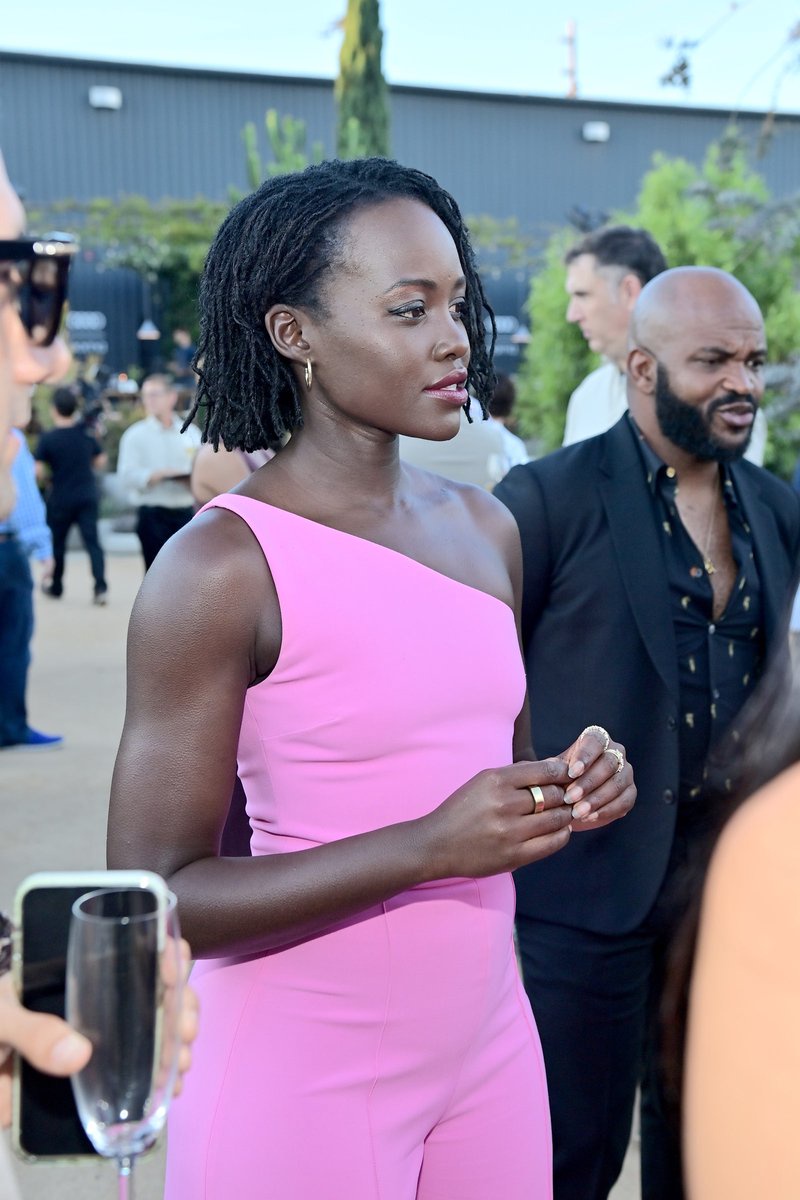 Lupita Nyong'o in a pink dress and mico locs bob hairstyle