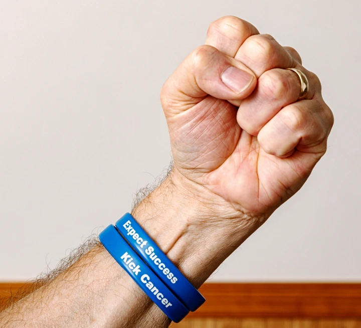 Raised fist wearing a bracelet with motivational text