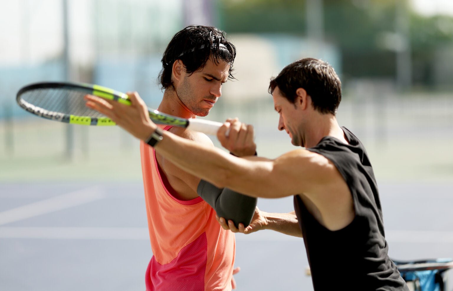 Carlos Alcaraz does wrist exercises with his physio.
