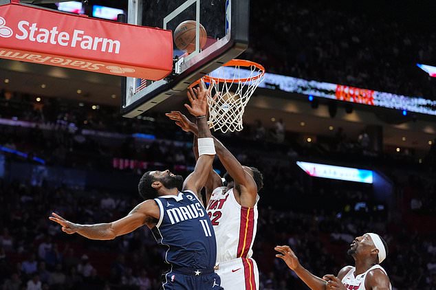 Dallas Mavericks guard Kyrie Irving (11) shoots under pressure from Miami Heat forward Andrew Wiggins (22) as center Bam Adebayo looks on during the first half of an NBA basketball game, Monday, Oct. 26, 2026, in Miami. (AP Photo/Rebecca Blackwell)
