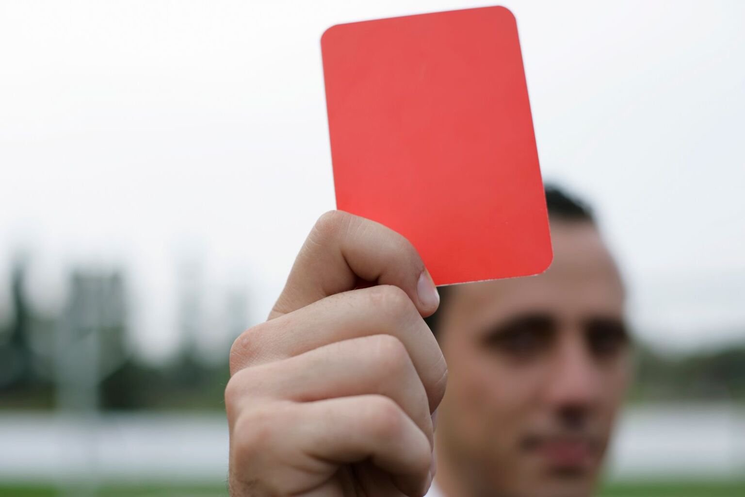 Referee holding up a red card during a football match