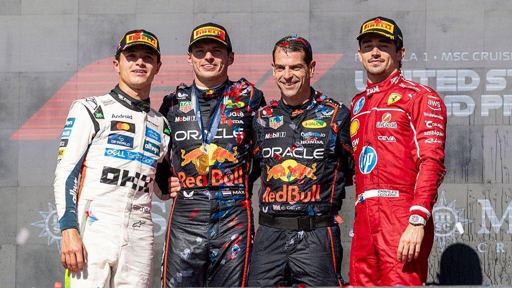 Max Vertsappen, Lando Norris and Charles Leclerc standing on the podium following the 2025 United States Grand Prix